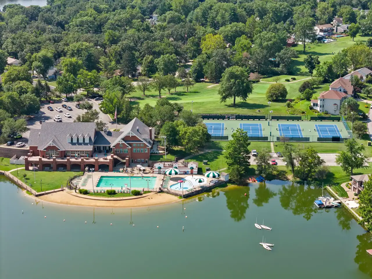 Aerial view of LSLCA clubhouse, pool, tennis courts, and golf course on the lake